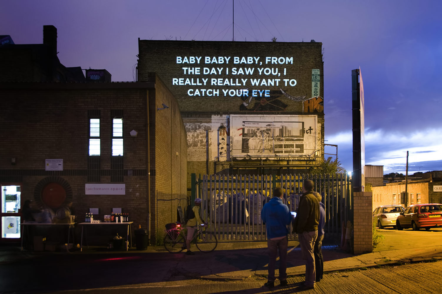 Song lyrics projected on the side of a building photographed by James Robertshaw