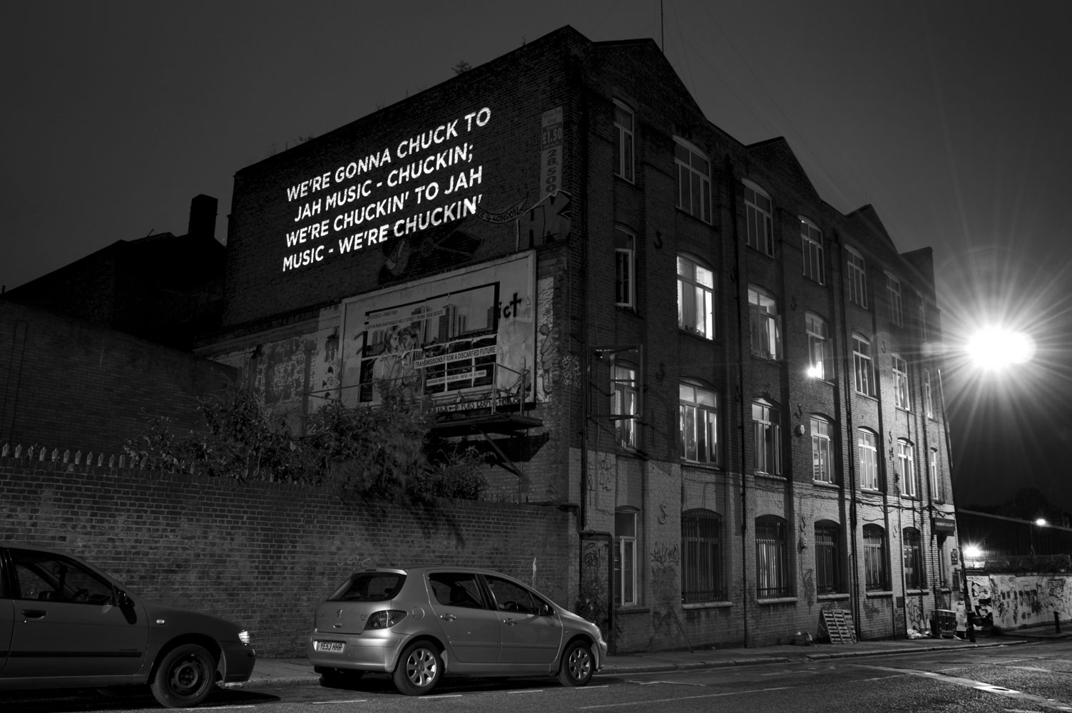 Song lyrics projected on the side of a building photographed by James Robertshaw