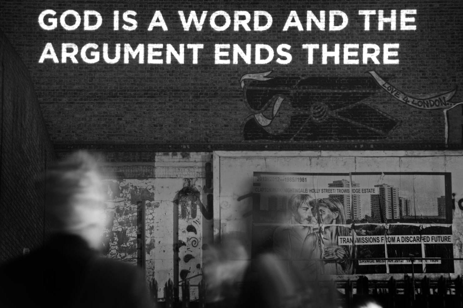 "God is word and the argument ends there" - Song lyrics projected on the side of a building photographed by James Robertshaw