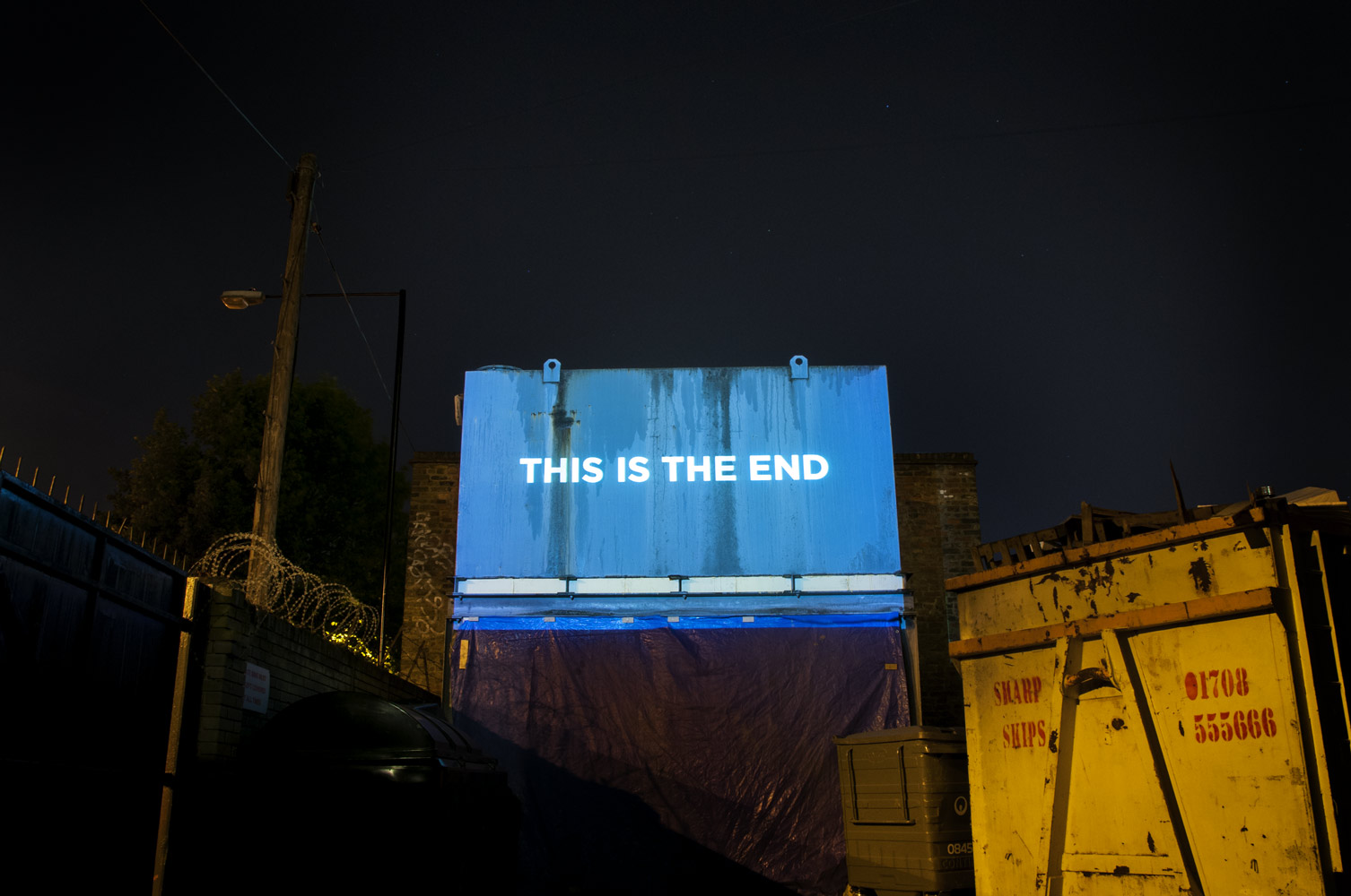 "This is the end" - Song lyrics projected on the side of a building photographed by James Robertshaw