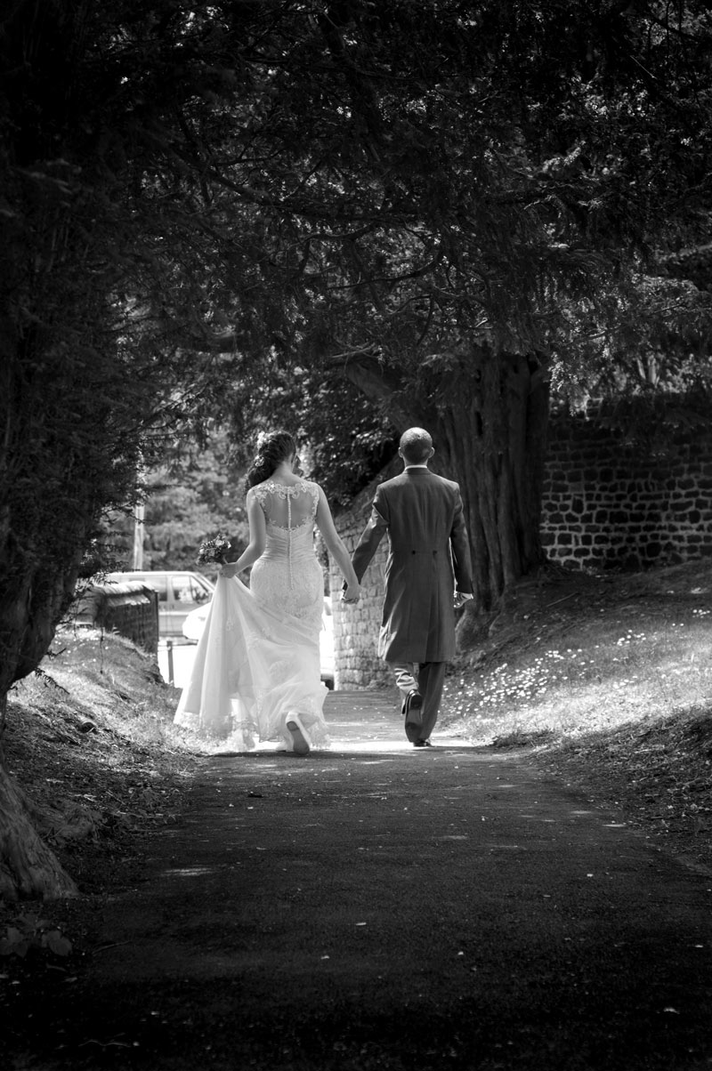 Bride and groom walking to wedding car