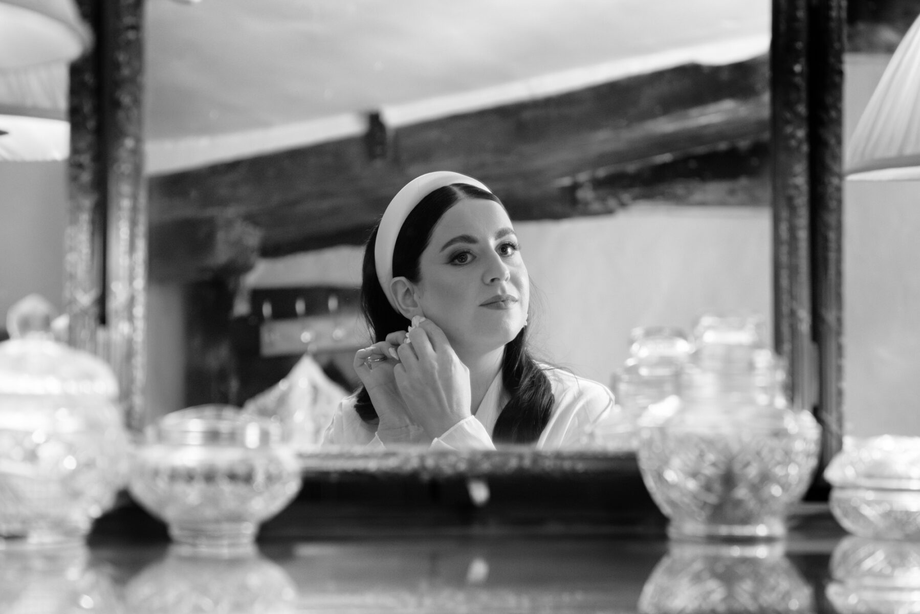 Bride putting on earing in mirror by Pilgrim's Rest wedding photographer, James Robertshaw