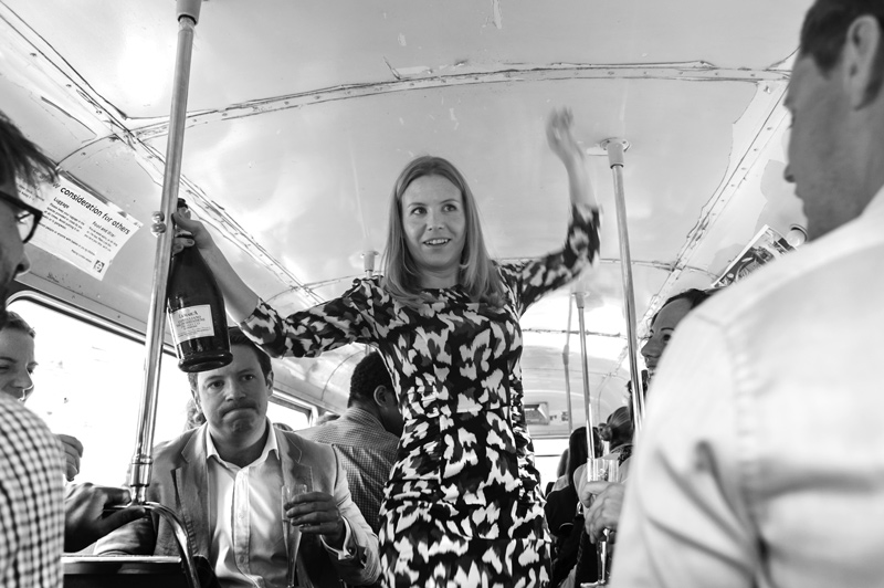 Woman holding champagne bottle on wedding bus