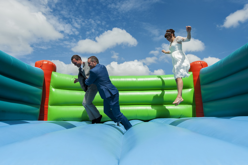 Couple on bouncy castle at Leeford place wedding by Sussex wedding photographer James Robertshaw