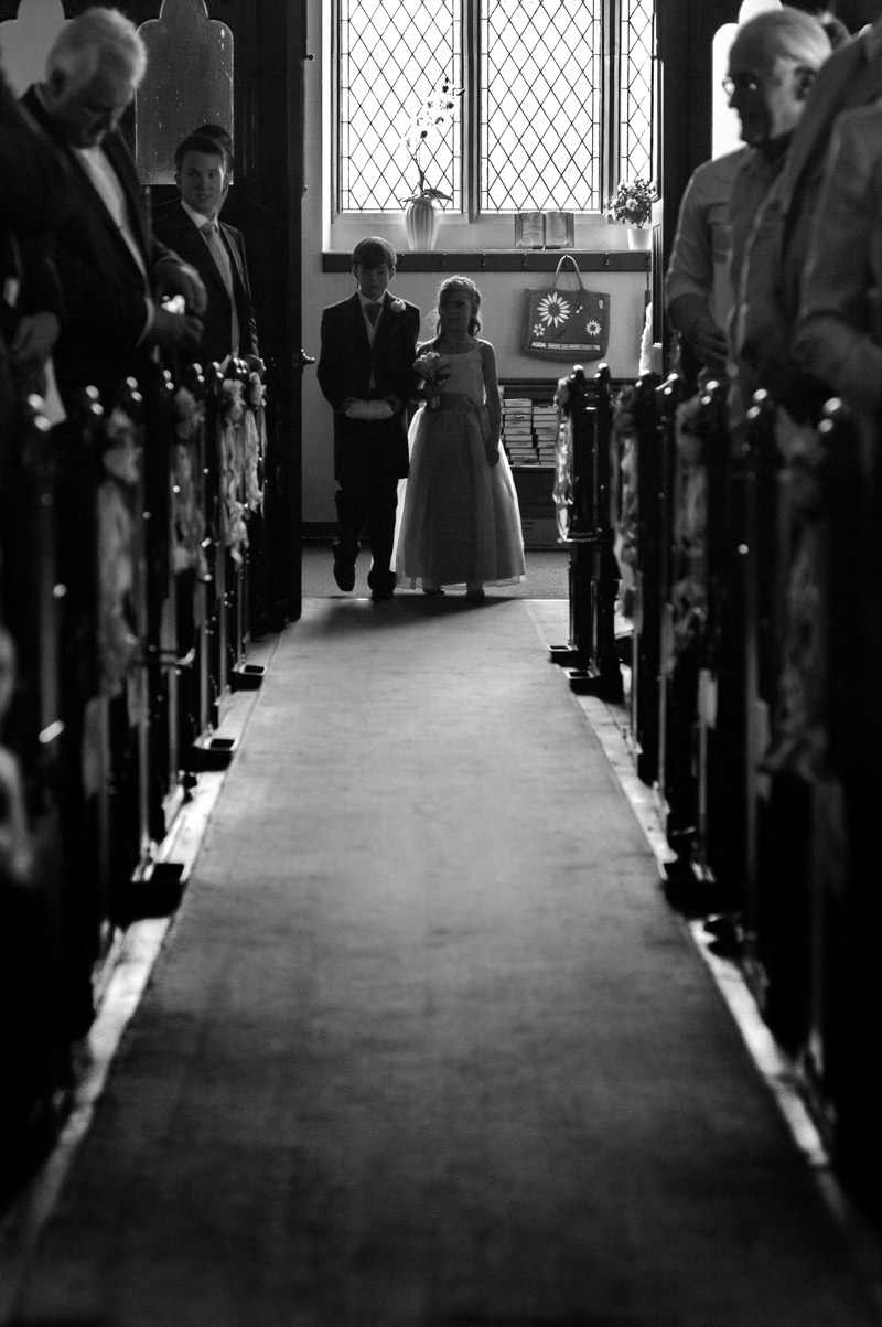 Page boy and bridesmaid walking down the isle by Sussex wedding photographer James Robertshaw