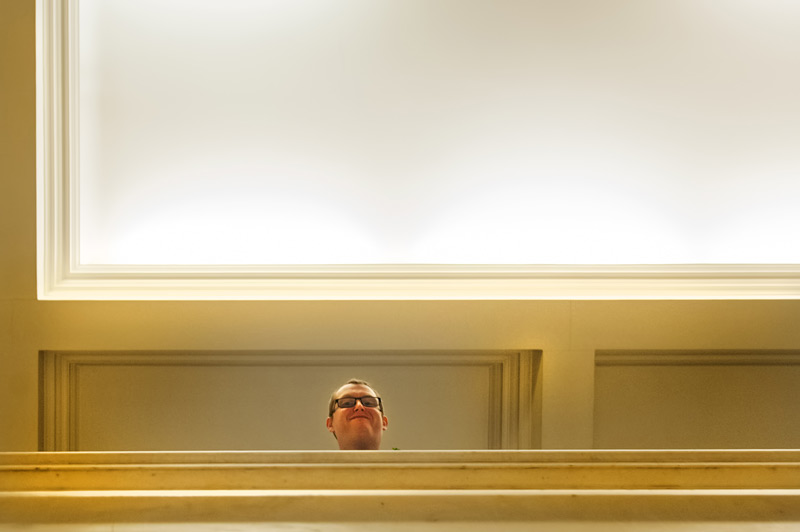 Wedding guest looking down at camera from balcony