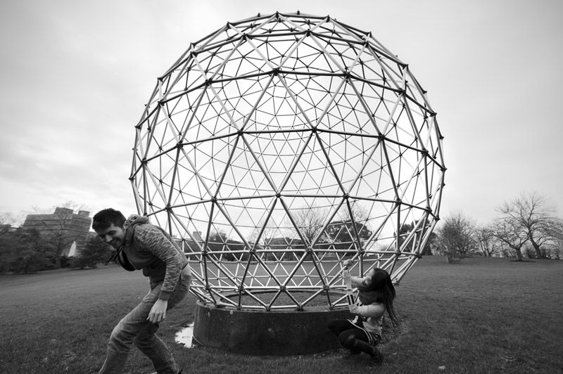 Couple climbing out of steel sphere - natural couple photography by James Robertshaw