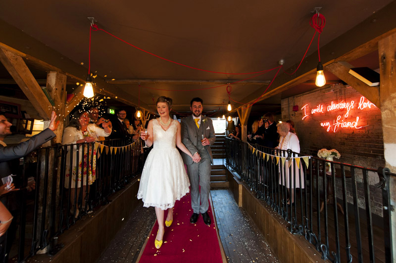 Bride and Groom walking down the table at The Bell Ticehurst wedding by Sussex wedding photographer James Robertshaw