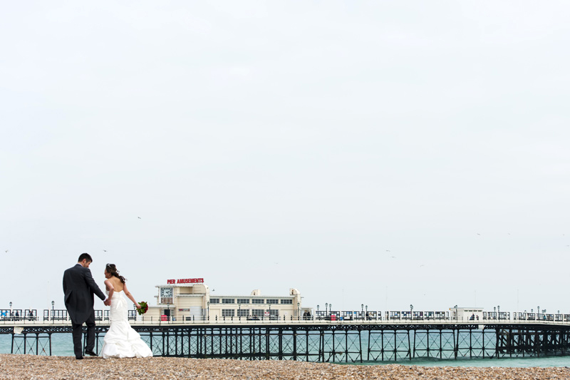 Newleyweds walking on the beach near Worthing Pier