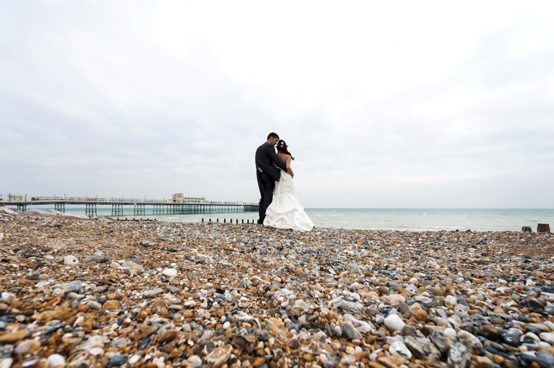 Newlyweds on the beach with Worthing Pier in background