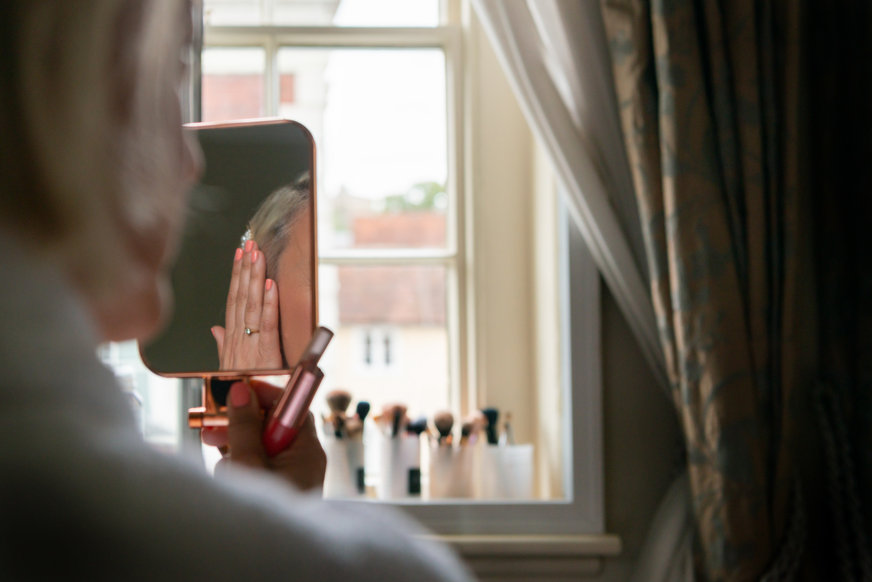 Bride's engagement ring reflected in mirror whilst getting make up done
